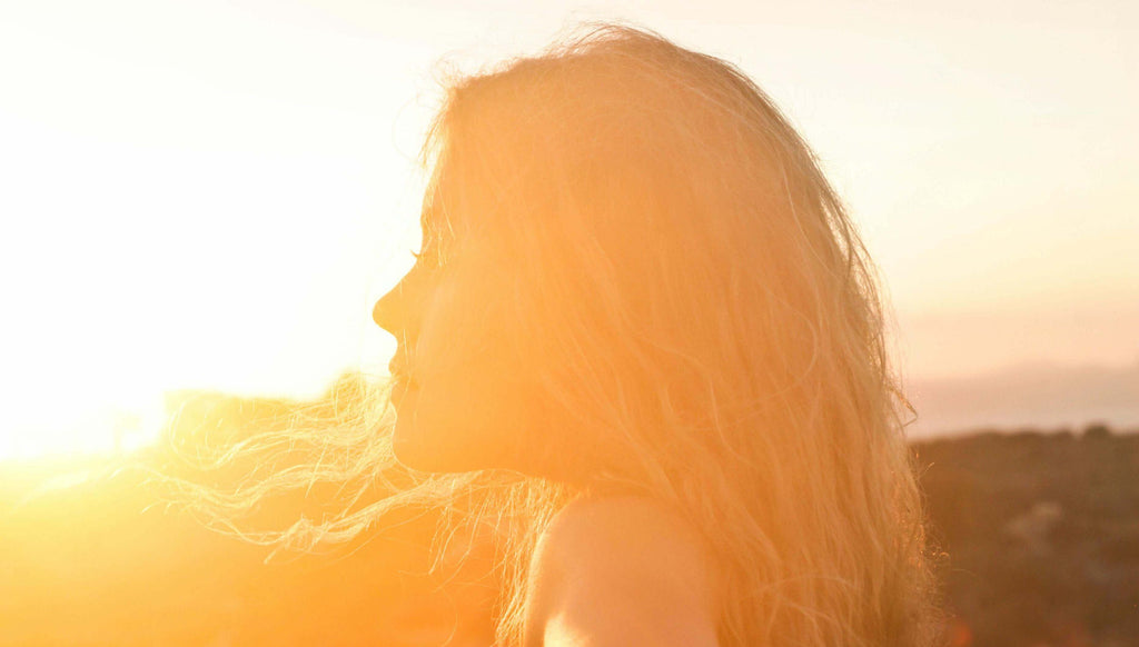 blonde woman standing in sunset