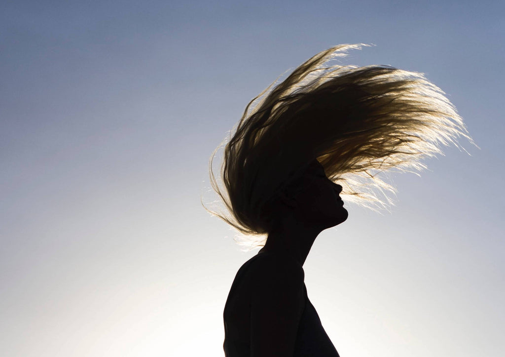 woman flipping long hair sunset