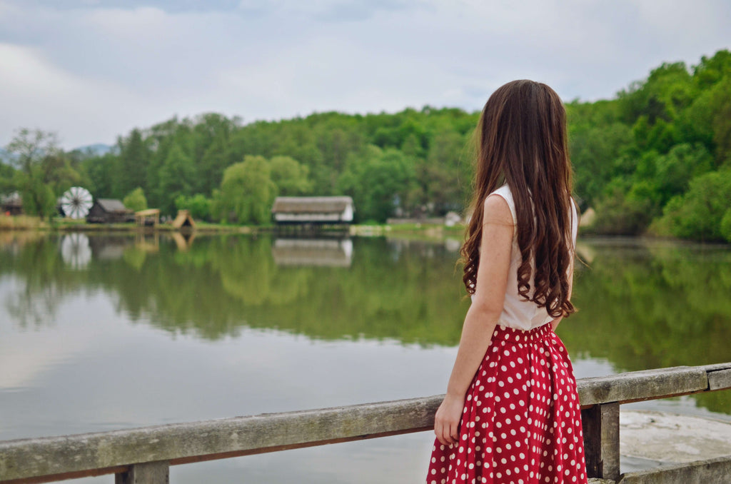 long hair brunette woman looking at lake