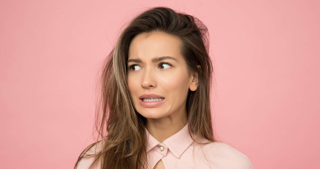 pink background frustrated brunette woman