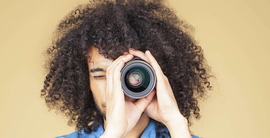 woman with curly hair holding camera