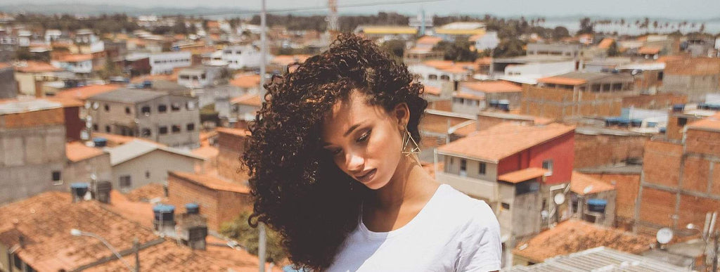 woman with curly hair buildings background