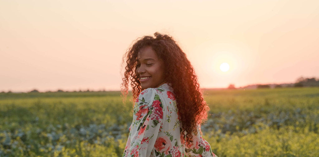woman with curly hair down with sun
